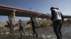Migrantes cruzan el río Bravo (Grande) hacia la frontera entre México y Estados Unidos, el 19 de diciembre de 2022, en Ciudad Juárez, México. 