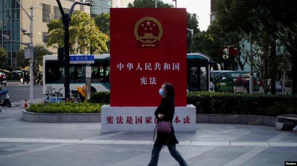 一名女子走过上海街头宣传中国宪法的宣传牌。（2021年11月12日）(photo:VOA)