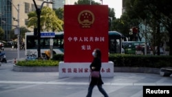 一名女子走过上海街头宣传中国宪法的宣传牌。（2021年11月12日）
