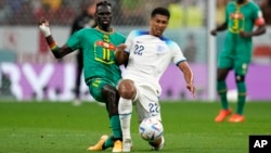 England's Jude Bellingham, right, and Senegal's Pathe Ciss challenge for the ball during the World Cup round of 16 soccer match at Al Bayt Stadium in Al Khor, Qatar, Dec. 4, 2022.