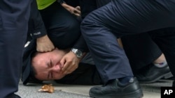 上海警察把一名抗議中國嚴厲防疫政策的青年壓倒在地。（2022年11月27日）