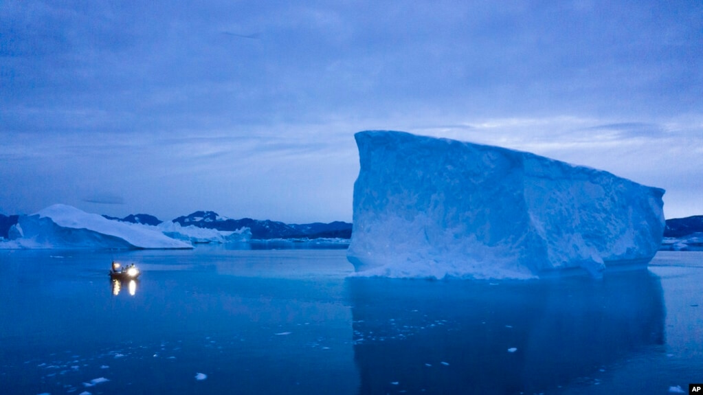 资料照片：一艘船驶过格陵兰岛东部的大座冰山。（2019年8月15日）