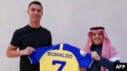 Cristiano Ronaldo receives the number seven jersey from Al Nassar's president Musalli Al-Muammar in Madrid on December 30, 2022