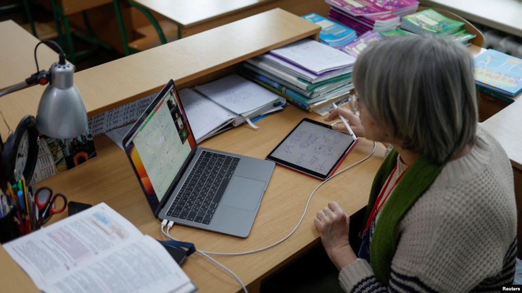 FILE - Teacher conducts an online chemistry lesson in a classroom at a school, amid Russia's attack on Ukraine, in Kyiv, Ukraine, Dec. 2, 2022. ( REUTERS/Valentyn Ogirenko)