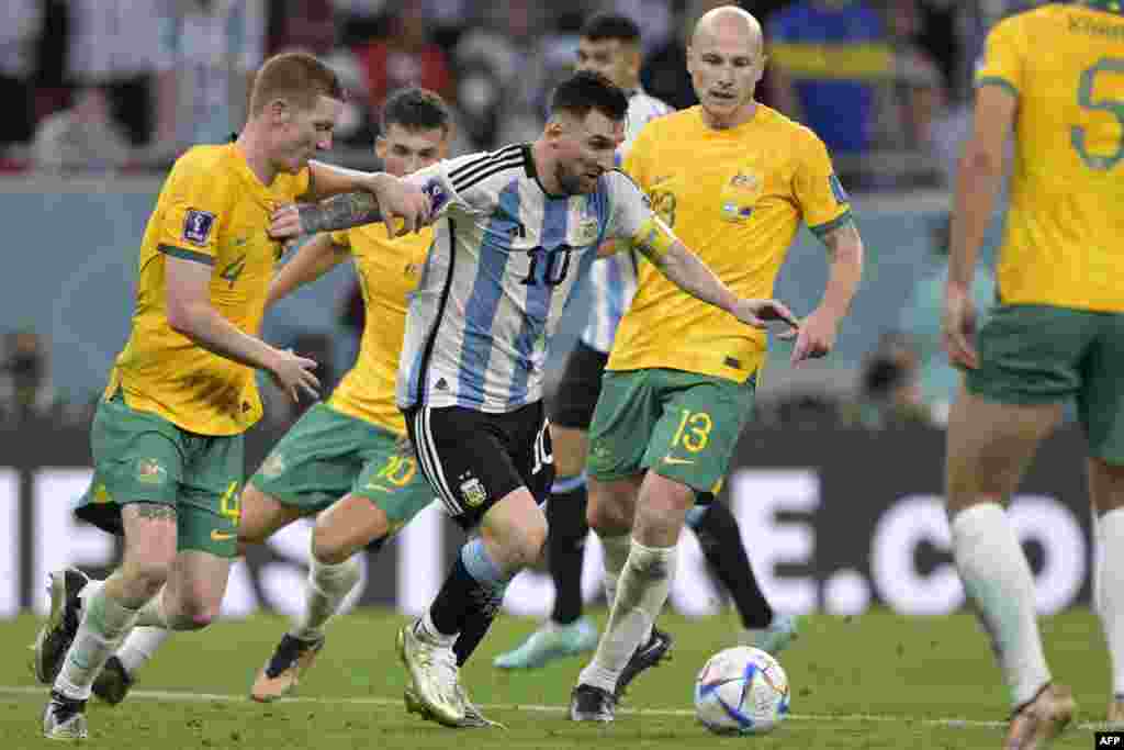 Attaquant ya Argentine #10 (C) Lionel Messi azali kowelela ndembo nadéfenseur ya Australie #04 Kye Rowels (G) mpe milieu ya Australie #13 Aaron Mooy na match ya 8e ya finales na Mondial Qatar 2022 na stade Ahmad Bin Ali na Al-Rayyan, Doha, 3 décembre 2022