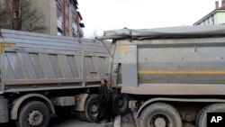 A barricade of trucks loaded with stones blocks a street in northern, Serb-dominated part of ethnically divided town of Mitrovica, Kosovo, Dec. 28, 2022. 