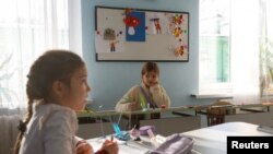 Daria Kosova attends a mathematic lesson at a private school, amid Russia's attack on Ukraine, in Kyiv, Ukraine, Dec. 1, 2022. 