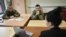 Ukrainian servicemen Ihor Soldatenko, left, and Yuriy Kalmutskiy attend an English lesson with teacher Olena Chekryzhova at a military facility in Kyiv, Dec. 21, 2022.