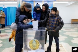 A family attend a polling station to vote in Astana, Kazakhstan, Nov. 20, 2022.