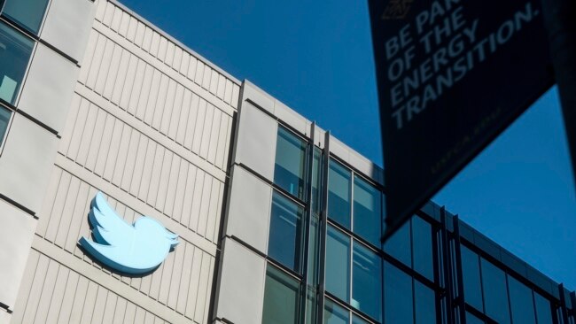 FILE - A Twitter logo hangs outside the company's San Francisco offices on Nov. 1, 2022.