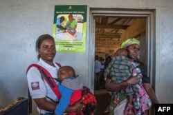 FILE - A poster warning in the vernacular Chichewa language that malaria is dangerous is seen at the beginning of the malaria vaccine implementation pilot project at Mitundu Community hospital in Malawi's capital district of Lilongwe, April 23, 2019.