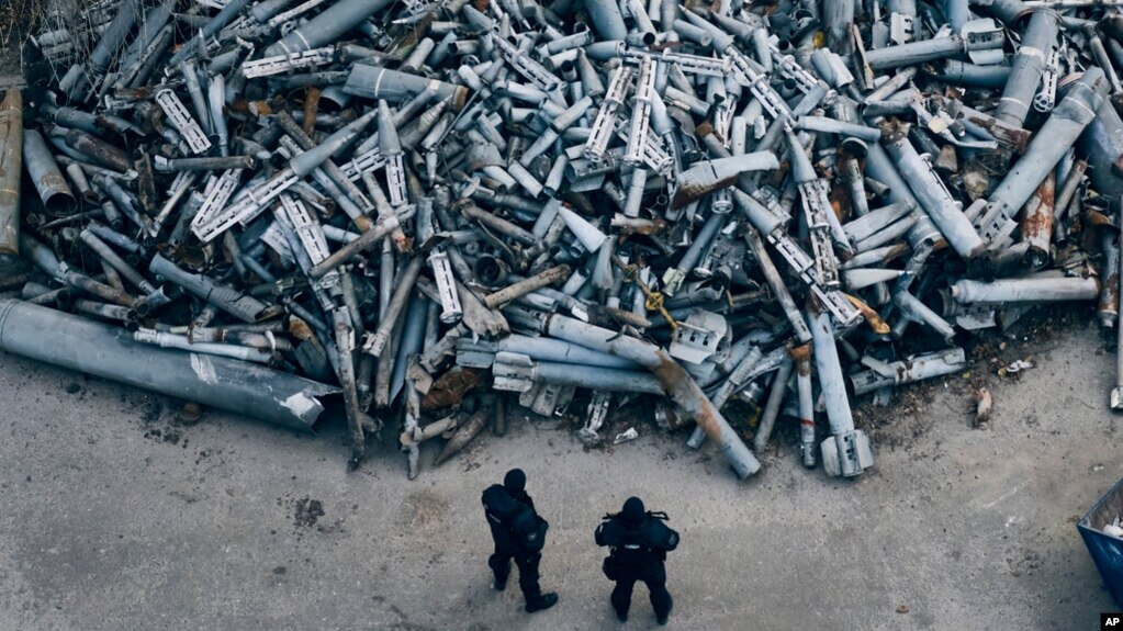 Police officers look at collected fragments of the Russian rockets that hit Kharkiv, in Kharkiv, Ukraine, Dec. 3, 2022. 