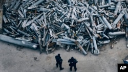 Police officers look at collected fragments of the Russian rockets that hit Kharkiv, in Kharkiv, Ukraine, Dec. 3, 2022. 