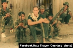 In this picture published on Nate Thayer's Facebook on Sept. 3, 2018, Nate Thayer sits alongside a group of young soldiers in the Khmer Rouge-controlled area in 1990. The caption published along this image said, "Two of my bodyguards in Khmer Rouge controlled jungles of Northern Cambodia, 1990. Their job was to shoot anybody that messed with me. There is nothing more dangerous than a ten year old with an AK-47. They do not know fear..." (Facebook/Nate Thayer)