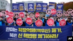FILE - Protesters rally to demand peace on the Korean peninsula in front of the presidential office in Seoul, South Korea, Nov. 3, 2022. The signs read 'South Korea and the US should scrap nuclear umbrellas.'