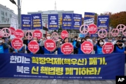 FILE - Protesters rally to demand peace on the Korean Peninsula in front of the presidential office in Seoul, South Korea, Nov. 3, 2022. The signs read, "South Korea and the US should scrap nuclear umbrellas."