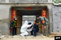 资料照：中国河南省夏邑县的医护人员上门给居民做核酸检测。（2022年5月10日）