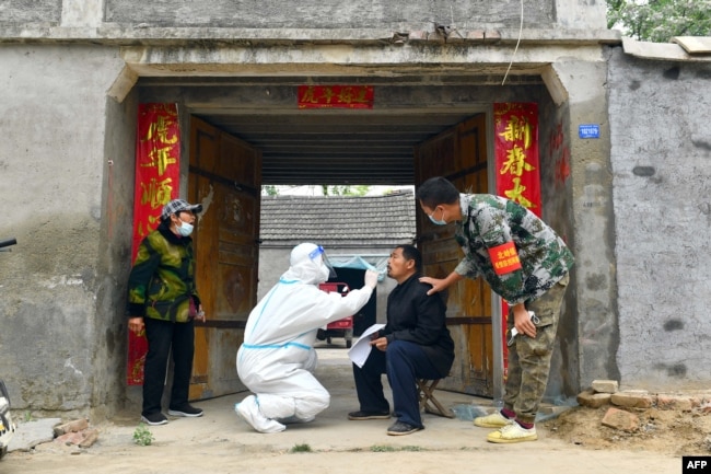 资料照：中国河南省夏邑县的医护人员上门给居民做核酸检测。（2022年5月10日）