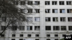 2023 年 1 月 1 日，一名男子在基輔的一座教育大樓附近扔碎玻璃，該大樓在前一天的導彈襲擊中受損。