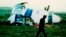 Foto Achiv: Yon polisye mache bo kote avyon Pan Am vol 103 ki tonbe sou vil Lockerbie, peyi Ekos, 21 Desanm 1988. 