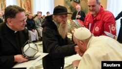 El papa Francisco besa la mano de un hombre durante la celebración de su 86 cumpleaños mientras se reúne con la delegación del Premio Madre Teresa en el Vaticano, el 17 de diciembre de 2022.