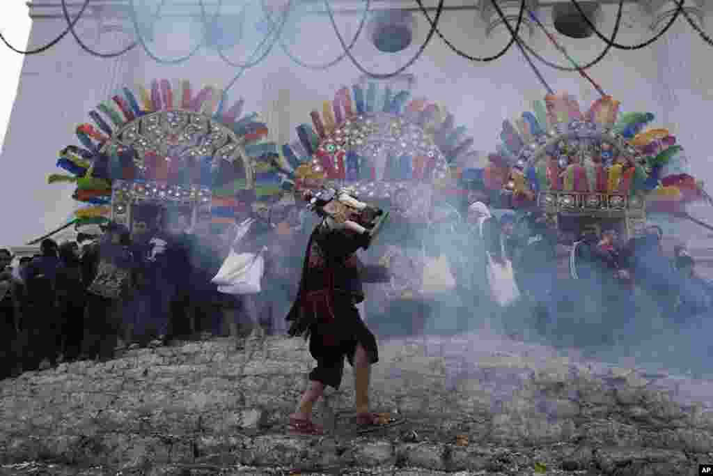 A brotherhood member carries a wooden statue of Santiago Apostle as part of a procession honoring the city's patron saint Saint Thomas, in Chichicastenango, Guatemala, Dec. 21, 2022.