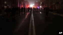 People walk at the city center which lost electrical power after yesterday's Russian rocket attack in Kyiv, Ukraine, Nov. 24, 2022.