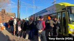 Migrantes esperan para subir a un autobús y resguardarse de las frías temperaturas en los alrededores de la iglesia Sagrado Corazón de El Paso, Texas, el 8 de enero de 2023.