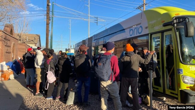 Migrantes esperan para subir a un autobús y resguardarse de las frías temperaturas en los alrededores de la iglesia Sagrado Corazón de El Paso, Texas, el 8 de enero de 2023.