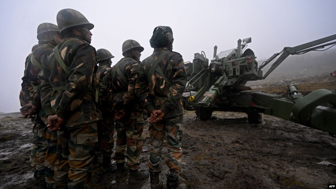 Tentara Angkatan Darat India berdiri di samping senjata Bofors yang ditempatkan di Penga Teng Tso di depan Tawang, dekat Garis Kontrol Aktual (LAC), negara tetangga China, di negara bagian Arunachal Pradesh, India pada 20 Oktober 2021. (Foto: AFP/Money SHARMA)