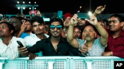 Laborers cheer at a fan festival at the Asian Town cricket stadium in Doha, Qatar, Friday, Nov. 25, 2022. (AP Photo/Jon Gambrell)