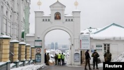 Ukrainian law enforcement officers stand next to an entrance to the Kyiv Pechersk Lavra monastery compound, amid Russia's attack on Ukraine, in Kyiv, Nov. 22, 2022. 