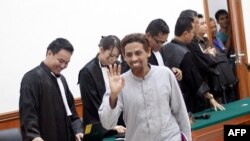 Umar Patek (tengah) melambaikan tangan kepada wartawan setelah satu hari lagi persidangannya di pengadilan Jakarta, 4 Juni 2012. (AFP / OSCAR SIAGIAN)