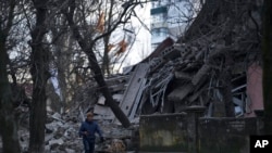 A man walks past a school building heavily damaged during a Russian attack in Kramatorsk, Donetsk region, Ukraine, Dec. 22, 2022. 