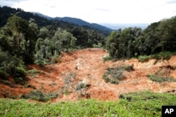 FILE - A landslide is seen at an organic farm in Batang Kali, Malaysia, Dec. 16, 2022.
