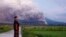 A man looks on as Mount Semeru releases volcanic materials during an eruption Dec. 4, 2022 in Lumajang, Indonesia.