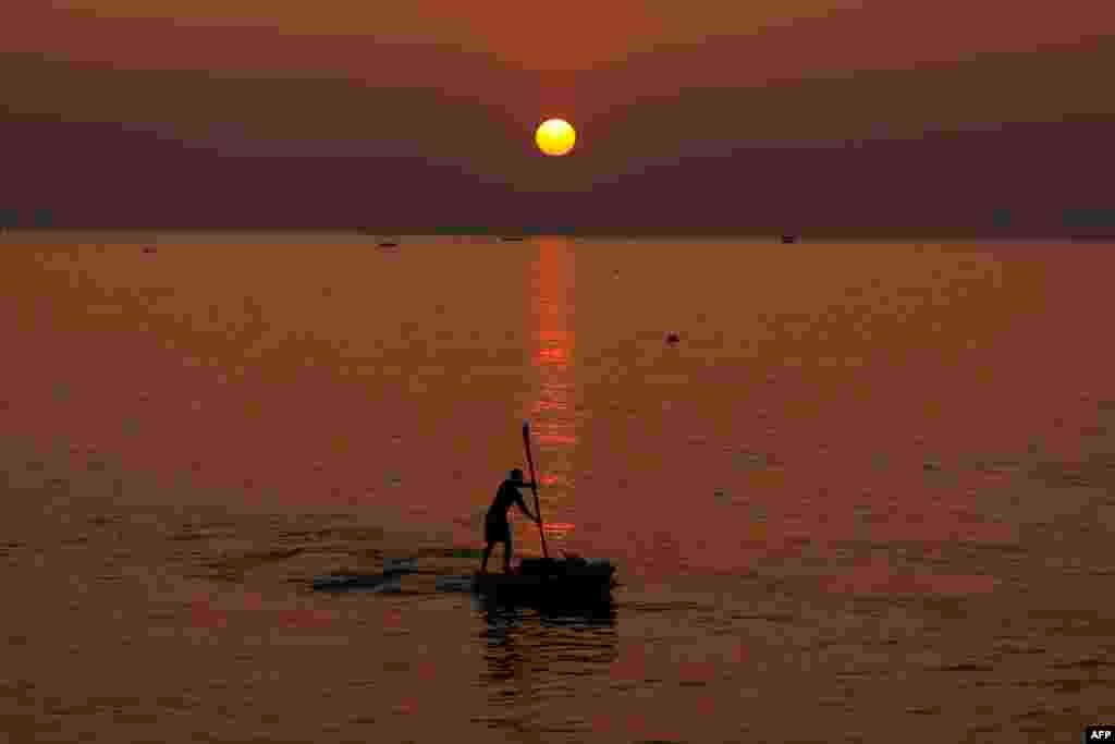 Seorang pria Palestina mendayung perahu saat matahari terbenam di lepas pantai Kota Gaza. (Foto: Mahmud Hams/AFP)&nbsp;