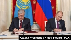 Kazakh President Kassym-Jomart Tokayev and Russian President Vladimir Putin sign bilateral documents in Moscow, Nov. 28, 2022. (Source: Kazakh President's Press Service)