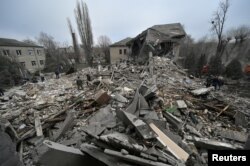 Tim evakuasi tampak bekerja di lokasi reruntuhan sebuah rumah sakit bersalin yang hancur akibat serangan rudal Rusia di Vilniansk pada 23 November 2022. (Foto: Reuters)