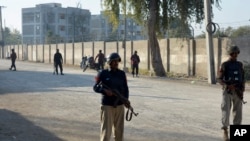 FILE - Security officials guard a blocked road leading to a counter-terrorism center after security forces starting to clear the compound seized earlier by Pakistani Taliban militants in Bannu, a northern district in the Pakistan's Khyber Pakhtunkhwa province, Dec. 20, 2022.
