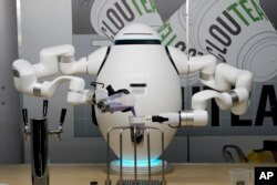 Yon wobo ADAM fe te boba nan demonstrasyon Richtech Robotics la pandan spektak CES la nan Las Vegas, Vandredi 6 Janvye, 2023.
