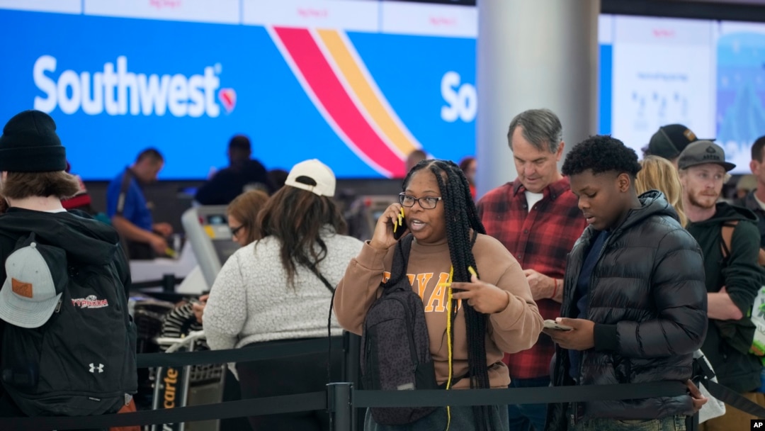 Travelers wade through the line for service at the Southwest Airlines check-in counter in Denver International Airport, Dec. 27, 2022.