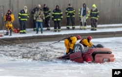 Kansas City fire department rescue workers work to recover a minivan that went into Brush Creek in Kansas City, Missouri, on Dec. 22, 2022.