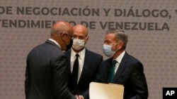 El presidente de la Asamblea Nacional de Venezuela, Jorge Rodríguez, a la izquierda, le da la mano al delegado de la oposición venezolana, Gerardo Blyde Pérez, en la Ciudad de México, el 13 de agosto de 2021. 