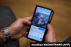 Oskar Arngarden, seorang pendeta Gereja Lutheran Swedia berusia 38 tahun, menelusuri video yang diposting di akun Instagramnya pada 30 Desember 2022, di Uppsala, Swedia. (Foto: AFP/Jonathan NACKSTRAND)