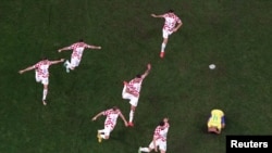 Los jugadores de Croacia celebran la clasificación para las semifinales mientras el brasileño Marquinhos (4) luce abatido tras la eliminación de su equipo a la Copa del Mundo, en el estadio de Lusail, Qatar, el 9 de diciembre de 2022.