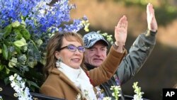 Grand Marshal Gabby Giffords, a former U.S. representative, and her husband, U.S. Senator Mark Kelly, wave to the crowd at the 134th Rose Parade in Pasadena, California, Jan. 2, 2023.