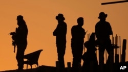 FILE - Pakistan police commandos stand guard on a rooftop while they observe the area to ensure the security of the rally of Pakistan's former Prime Minister Imran Khan's 'Pakistan Tehreek-e-Insaf' party, in Rawalpindi, Pakistan, Nov. 26, 2022. 