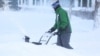 A man clears snow from his driveway following a winter storm that hit the Buffalo region in Amherst, New York, Dec. 25, 2022. 