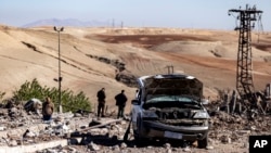 People inspect a site damaged by Turkish airstrikes that hit an electricity station in the village of Taql Baql, in Hasakeh province, Syria, Nov. 20, 2022.